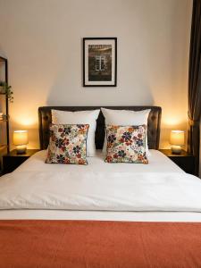a bed with two pillows on it with two lamps at Le Duplex Thionville centre Gare à pied in Thionville