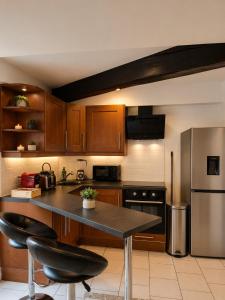 a kitchen with wooden cabinets and a stainless steel refrigerator at Le Duplex Thionville centre Gare à pied in Thionville +12 photos