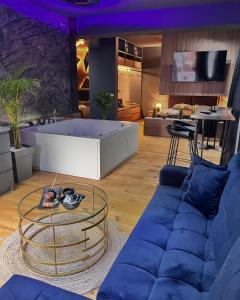 a living room with a blue couch and a table at TULUM luxury suites-SKOPJE in Skopje