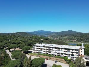 an apartment building with trees and mountains in the background at Residenza Verde Blu - ArgonautiVacanze in Capoliveri