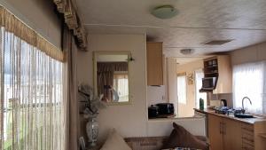 a kitchen with a person taking a picture in a mirror at Golden sands 326 3 bedroomed caravan in Ingoldmells