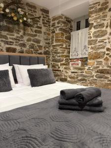 a bedroom with two beds and a stone wall at La mina's house in Symi