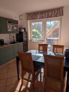 a kitchen with a table and chairs and a window at " FeWo am Hof " Große Wohnung mit zwei Schlafzimmern, seperate Küche und großem Bad in Beverstedt
