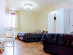 a living room with two beds and a chair at Alloggio Turistico EDEN - Lubriano in Lubriano