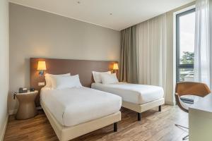 a hotel room with two beds and a window at MOVE Hotels Venezia Nord in Mogliano Veneto +44 photos
