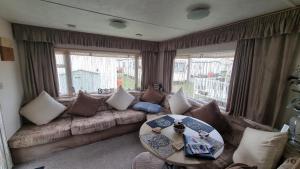 a living room with a couch and a table at Golden sands 326 3 bedroomed caravan in Ingoldmells