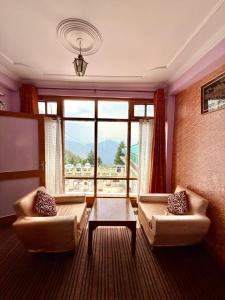 a living room with two couches and a large window at vishwaram Homestay in Chail +33 photos