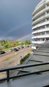 a rainbow over a parking lot with a building at Apartament "DESTINATION" przy AQUAPARKu in Reda