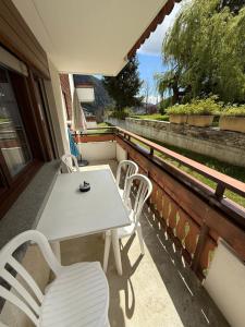 a white table and chairs on a balcony at Gonenstein 11 in Leukerbad