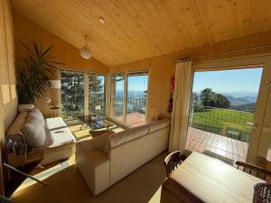 a living room with a couch and a large window at Panoramic views on Monte Generoso, peace & nature in Castel San Pietro