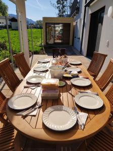 a wooden table with plates and utensils on it at "Villa Barta am See" - Salzkammergut erleben in Traunkirchen