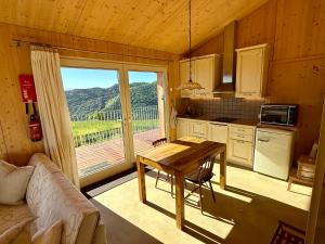 a kitchen with a table and a large window at Panoramic views on Monte Generoso, peace & nature in Castel San Pietro