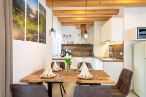 a kitchen and dining room with a wooden table and chairs at Apartmaji MM in Bohinj