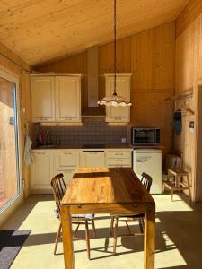 a kitchen with a wooden table and chairs at Panoramic views on Monte Generoso, peace & nature in Castel San Pietro