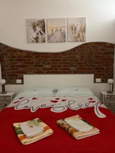 a bedroom with a red bed with towels on it at Maison 24 in Tuscania