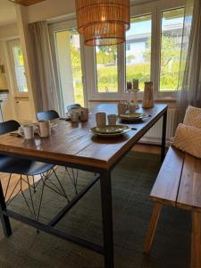 a wooden table with cups and plates on it in a room at inHome Vista Murten in Murten