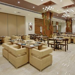a restaurant with tables and chairs in a room at Hotel Bellwood Near IGI International Delhi Airport in New Delhi