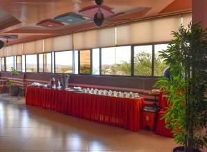 a restaurant with a long red table with glasses at Two Oceans Hotel Voi in Voi