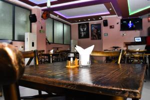 a wooden table in a restaurant with a drink on it at Two Oceans Hotel Voi in Voi