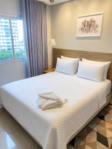 a hotel room with a bed with two towels on it at Apollos Garden in Belém +34 photos