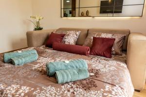 a bed with pillows on it with a couch at Apartman Srebrni Horizont in Veliko Gradište +28 photos