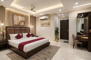 a bedroom with a bed and a desk and a television at Hotel Bellwood Near IGI International Delhi Airport in New Delhi