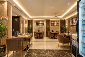 a restaurant with tables and chairs in a room at Hotel Bellwood Near IGI International Delhi Airport in New Delhi