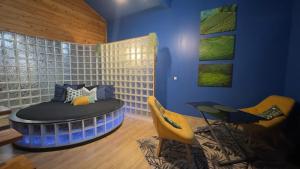 a room with a bed and two yellow chairs at chambre AZZURO avec jacuzzi lit rond et jardin avec piscine in Saint-Martial-sur-Né +7 photos