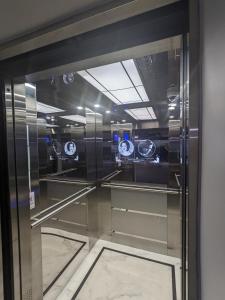 a glass elevator in a room with clocks on the wall at Fantasea Condo Kamala 1bdr in Kamala Beach