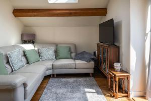 a living room with a couch and a flat screen tv at The Damson Barn in Biddulph