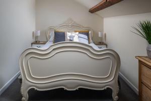 a large white bed in a room with aitures at The Damson Barn in Biddulph +27 photos