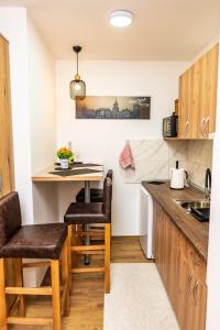 a small kitchen with a small table and chairs at Apartman Srebrni Horizont in Veliko Gradište