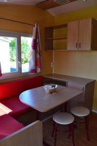 a small kitchen with a table and two stools at Camping 3 étoiles - Piscine - ccbgaae in Mens