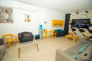 a living room with a couch and chairs and a tv at Hotel Santa María in Mazatlán