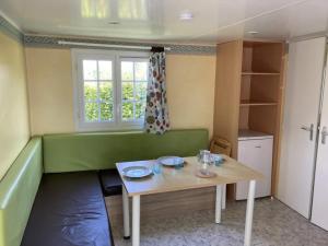 a living room with a green couch and a table at Camping 3 étoiles - Piscine - ccbfghc in Mamers