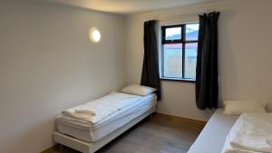 a small room with two beds and a window at Ocean View Guesthouse in Borgarnes