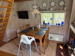 a dining room with a wooden table and chairs at Mosters hus in Gansbyn +5 photos