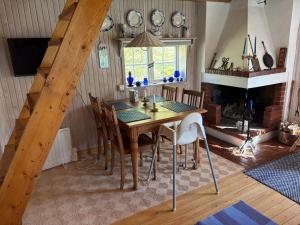 a dining room with a table and a fireplace at Mosters hus in Gansbyn