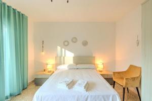 a bedroom with a white bed with two towels on it at Estartit Centro in L'Estartit