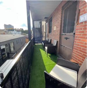 a balcony with chairs and tables on a building at Serendipity Corner Guesthouse in Wilkes-Barre