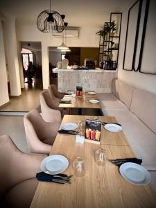 a dining room with a table and chairs with plates and glasses at Hotel tafoukt in Marrakesh