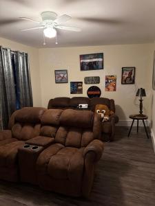 a living room with a brown couch and a ceiling fan at Serendipity Corner Guesthouse in Wilkes-Barre