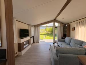 a living room with a couch and a tv at Green Lodge Bran in Bran