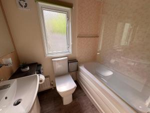 a bathroom with a toilet and a tub and a sink at Green Lodge Bran in Bran +5 photos