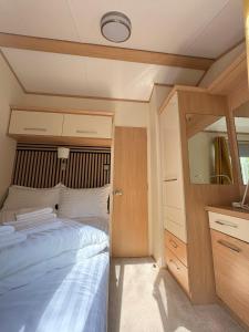 a small bedroom with a bed and a mirror at Green Lodge Bran in Bran