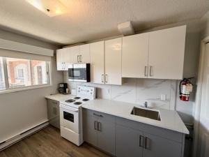 a kitchen with white cabinets and a white stove top oven at Schell Motel in Vernon