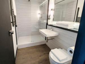 a bathroom with a toilet and a sink and a shower at The Crossway Hotel, Coventry Walsgrave, Part of AG Collection in Coventry