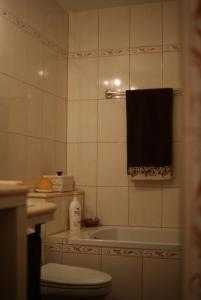 een badkamer met een bad, een toilet en een handdoek bij Apartament Ametyst in Jelenia Góra