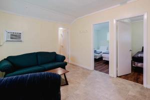 a living room with a green couch and a bedroom at 2-Bedroom Cottage #1 - Ambleside in Kawartha Lakes