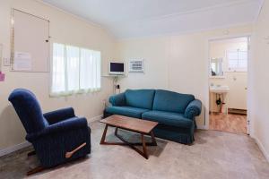 a living room with two blue chairs and a table at 2-Bedroom Cottage #1 - Ambleside in Kawartha Lakes